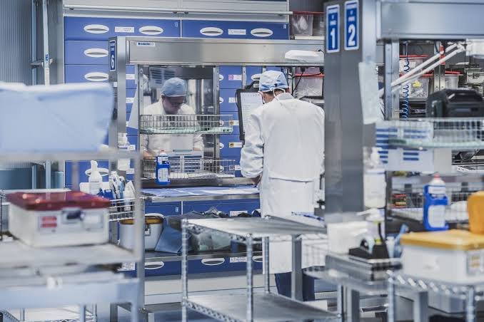 Centrale di sterilizzazione con operatori e carrelli di strumenti