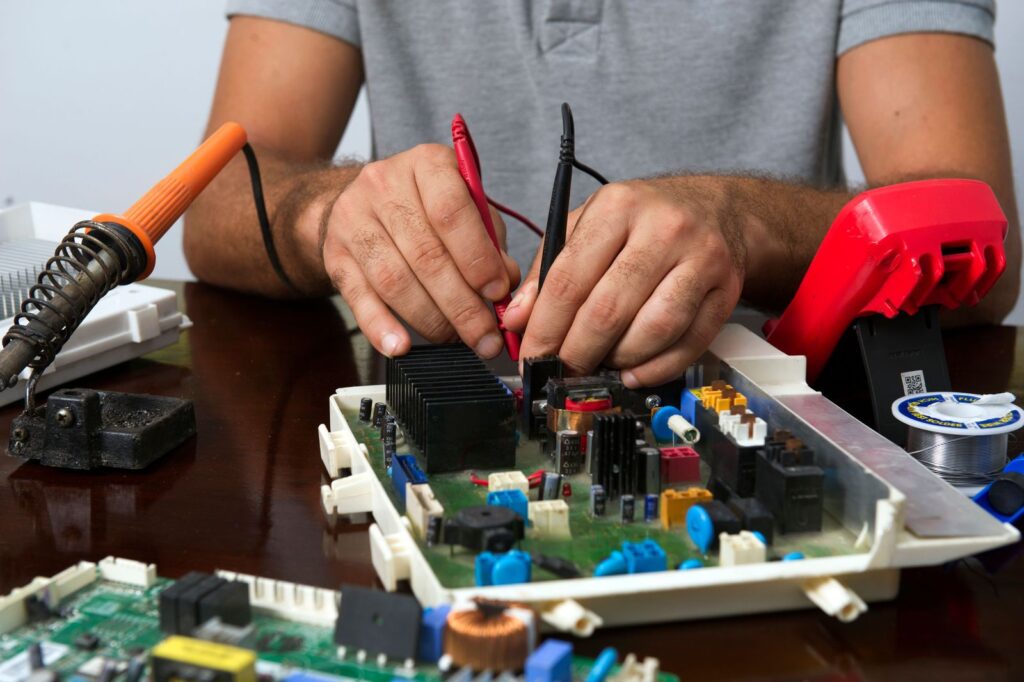 Tecnico che misura con il tester una scheda elettronica