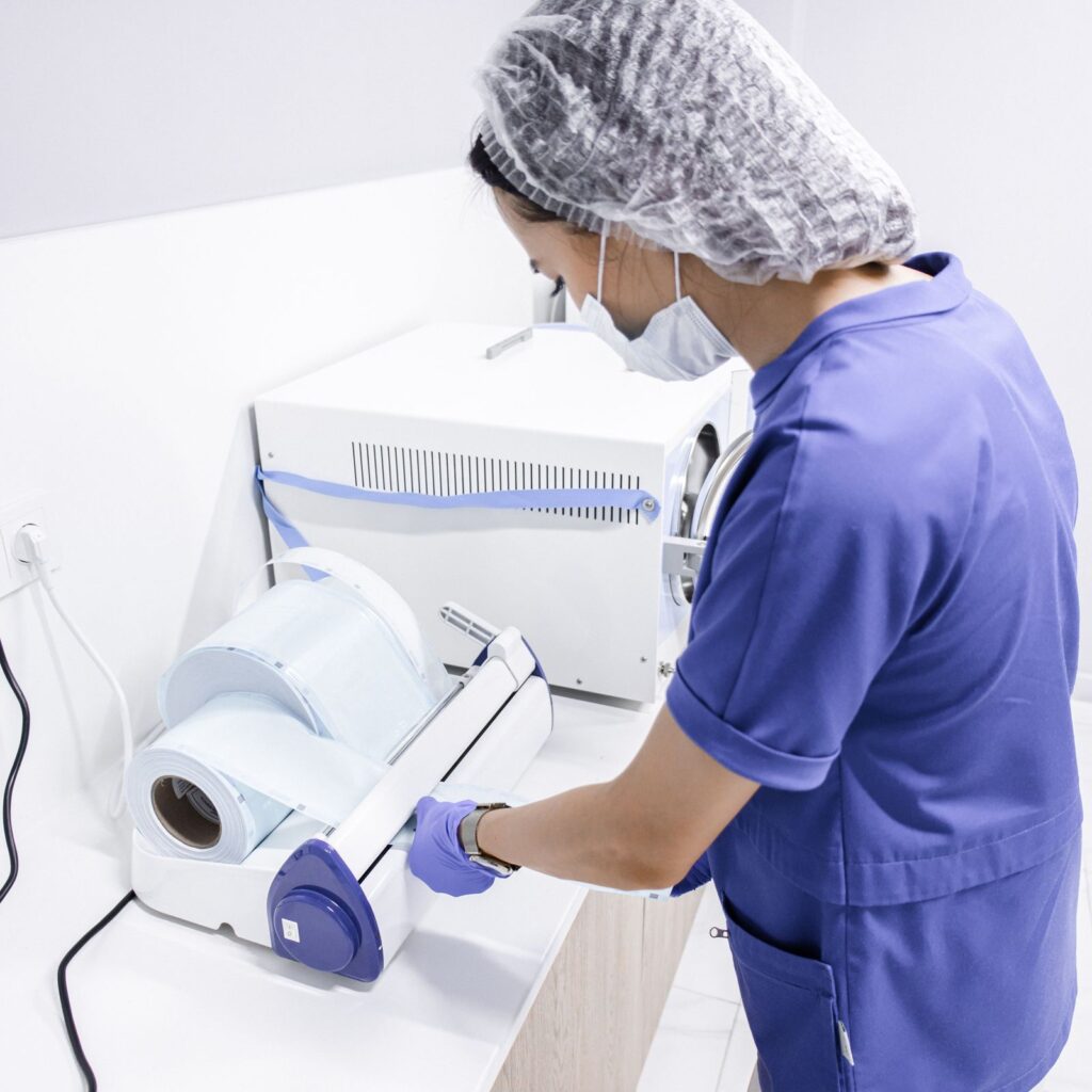 Operatrice che sigilla le buste degli strumenti con la termosigillatrice
